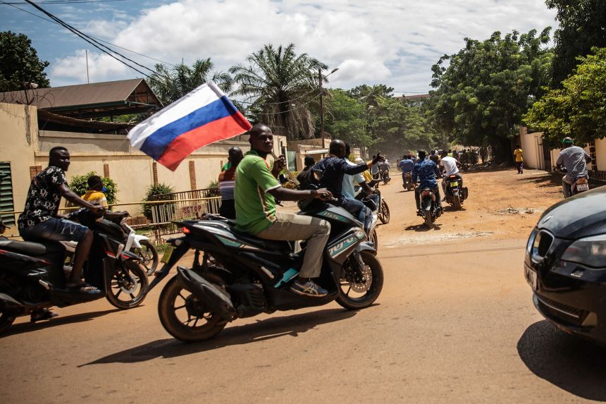 Supporters of junta leader Capt. Ibrahim Traore wave a Russian flag in the streets of Ouagadougou, Burkina Faso, on Oct. 2, 2022.