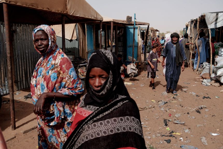People walk through the weekly market in M'Berra camp in Bassikounou on June 7, 2022. The camp, in Mauritania, is one of the largest in West Africa, hosting refugees fleeing violence in Mali.