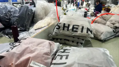 Reuters Packs of clothing are pictured at a garment factory for Shein in Guangzhou, Guangdong province, China 1 April, 2025.
